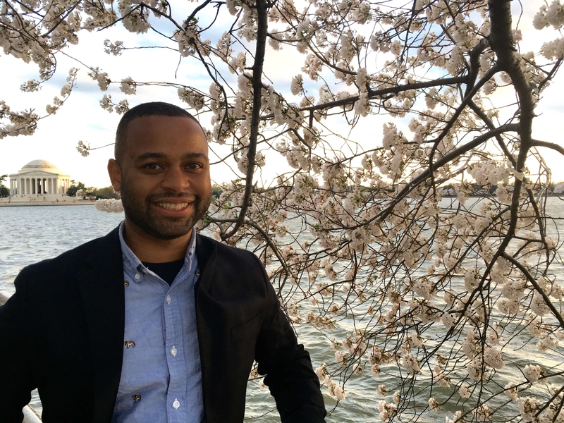 Thomas Searles in front of a cherry blossom and the Tidal Basin in Washington